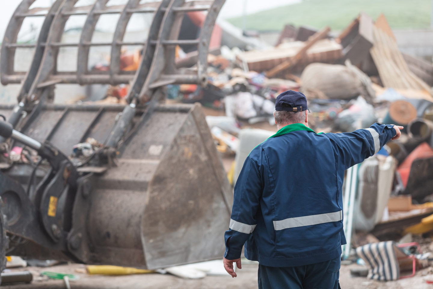 Operatore che coordina le operazioni in un'area di stoccaggio rifiuti