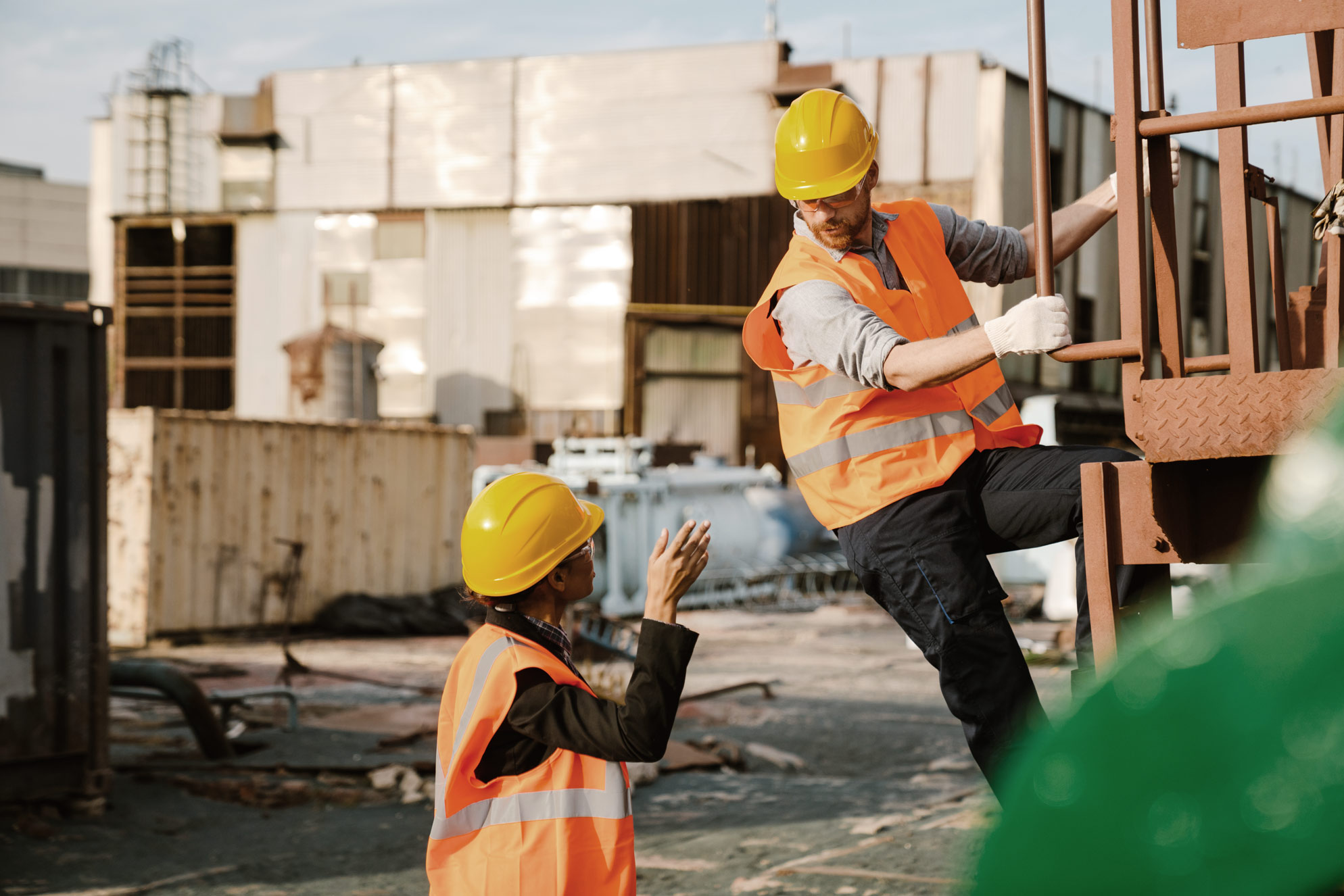 Operai con casco e giubbotto ad alta visibilità al lavoro in un'area industriale